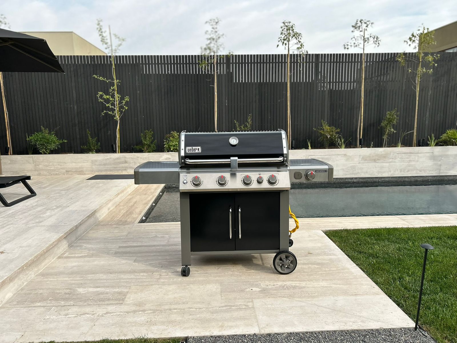 Parrilla Weber Genesis lista junto a la piscina